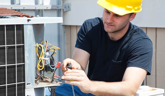 HVAC technician repairing air conditioner electrical wiring