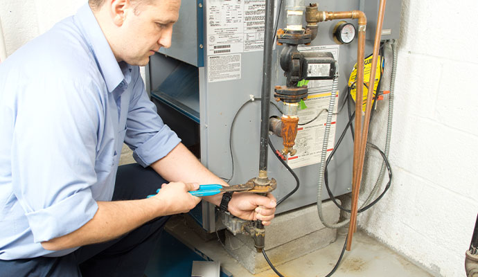 HVAC technician repairing boiler system pipe HVAC technician repairing boiler system pipe