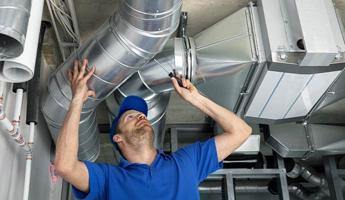 HVAC technician repairing ventilation ducts