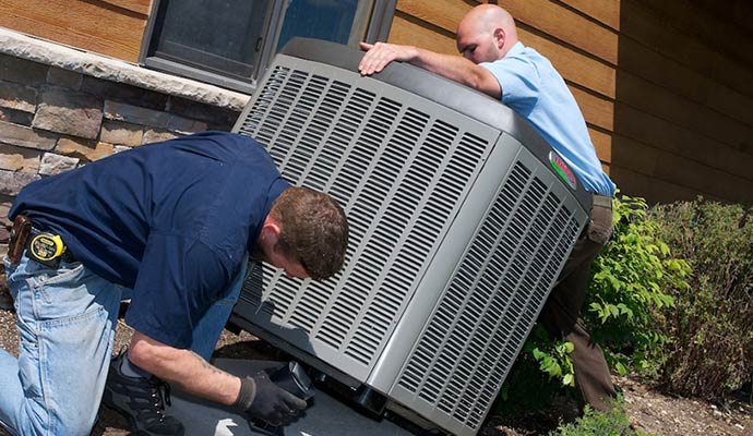 HVAC technicians installing new outdoor AC unit
