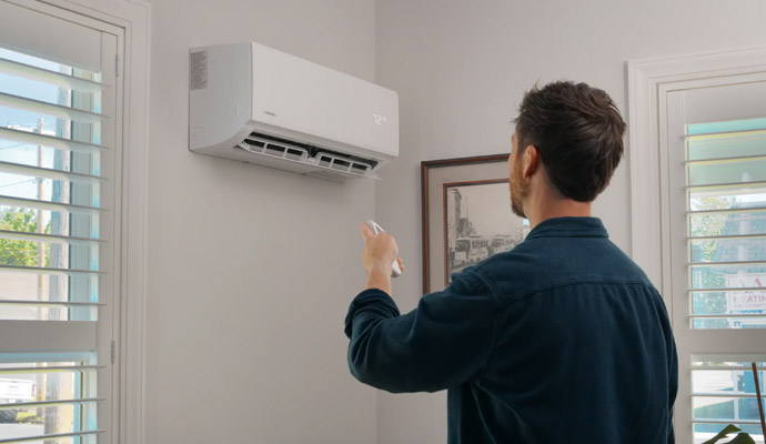 Man using remote control air conditioner