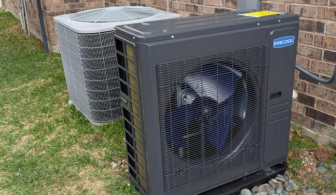 MrCool side discharge heat pump next to old AC unit