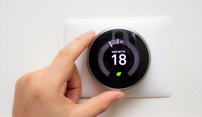 Person adjusting a smart thermostat