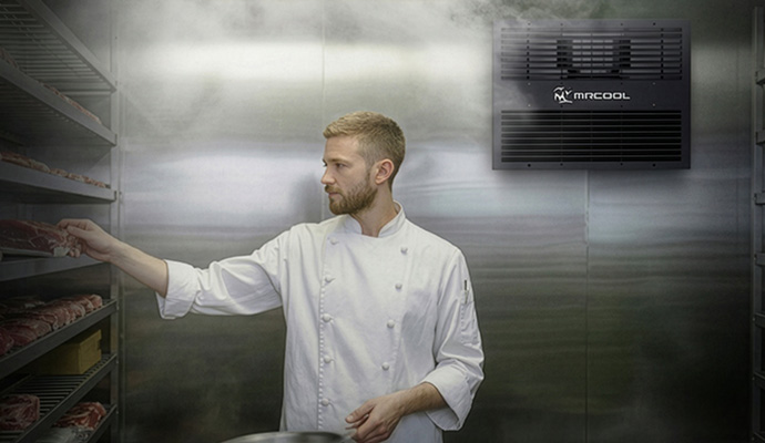 Professional chef collecting meat from a walk-in cooler refrigeration unit