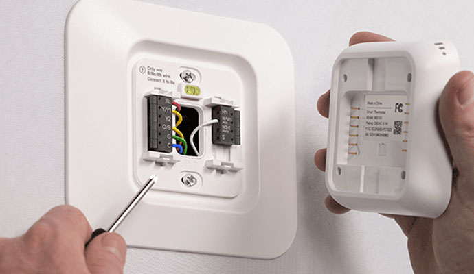 Technician installing a smart thermostat