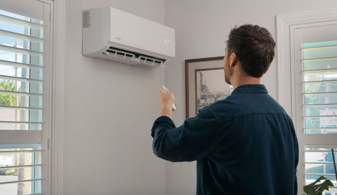 User controlling air conditioner with remote control